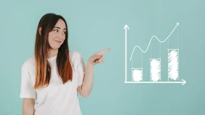 Hogyan mérheted a weboldalad forgalmát egyszerűen? témájú cikk kiemelt képe: egy lány, aki a falra rajzolt grafikonokra mutat